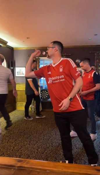 飞镖世界杯冠军穿着诺丁汉森林队的球衣到当地酒吧与学校业余爱好者一起摇摆，震惊了球迷
