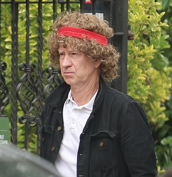 约翰·麦肯罗 (John McEnroe) 在温布尔登网球公开赛前戴着滑稽的假发，再现了 80 年代的标志性造型