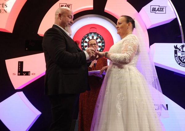 飞镖明星在世界锦标赛被淘汰后立即在舞台上与长期伴侣结婚