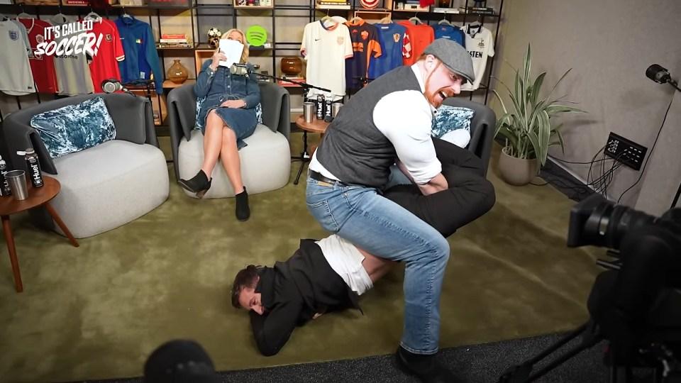 观看疯狂时刻 WWE 传奇人物希莫斯让加里·内维尔痛苦地翻滚，曼联传奇人物猛击利物浦